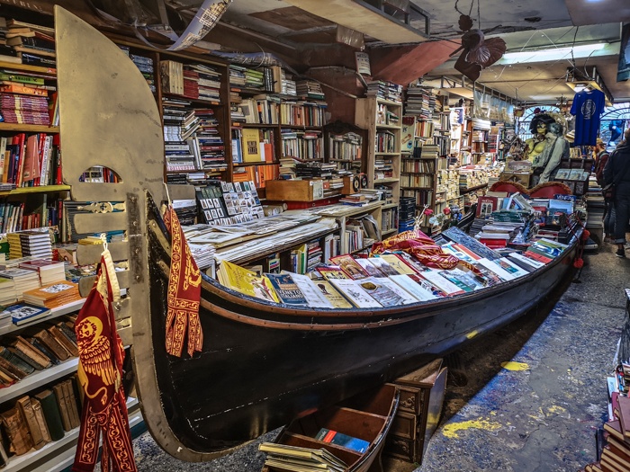 the gondola of Libreria Acqua Alta in Venice Italy, full to the brim with books to buy.