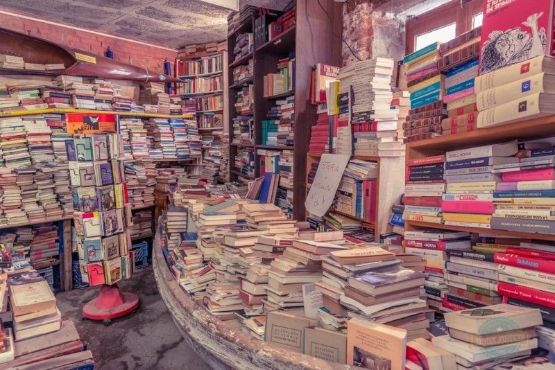 Libreria Acqua Alta Stacks of books in Boat in Venice Italy. This is to help prevent damage during acqua alta which happens each winter in this sinking city.