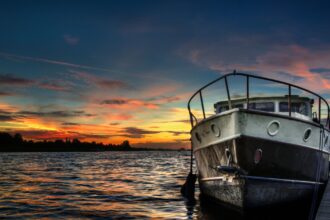 The front of a boat in the lake, something that you might holiday on for a weekend or longer.