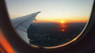Looking out of the airplane window as the sun is setting over the city