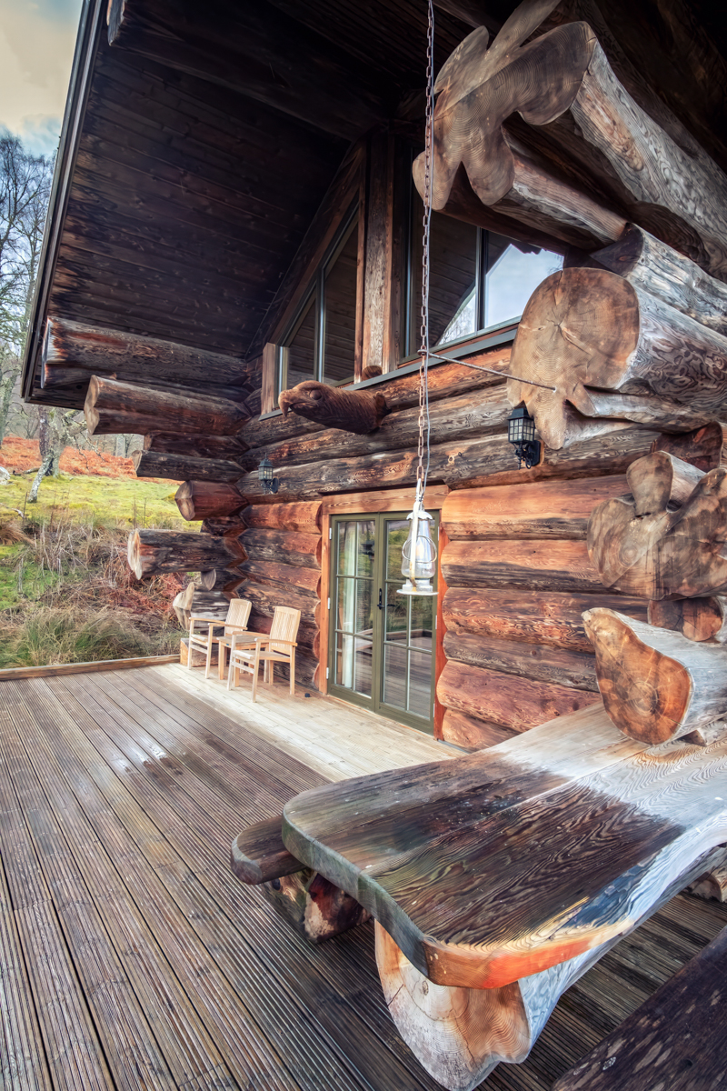 Handcrafted wooden exterior and balcony seating at Eagle Brae luxury log cabin in the Scottish Highlands near Inverness showcasing detailed log construction