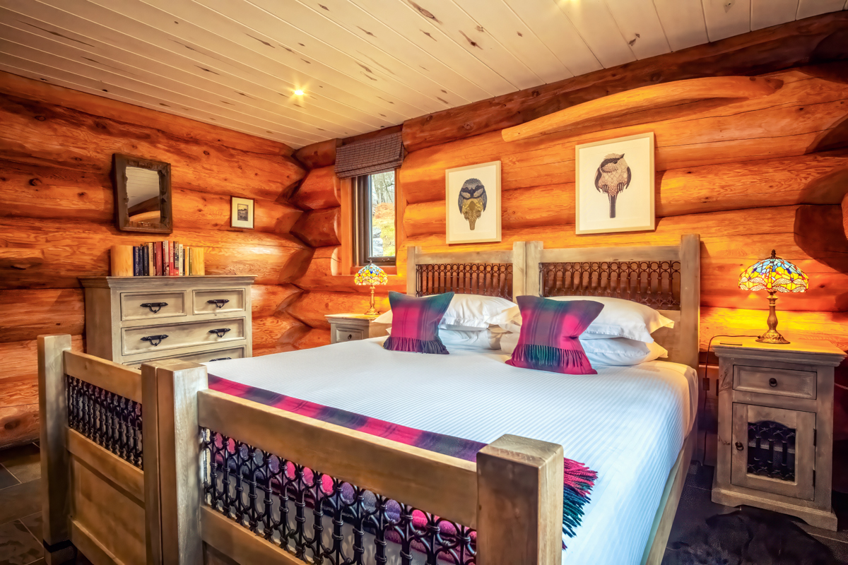 Rustic wooden bedroom with carved details in Eagle Brae lodge Scotland