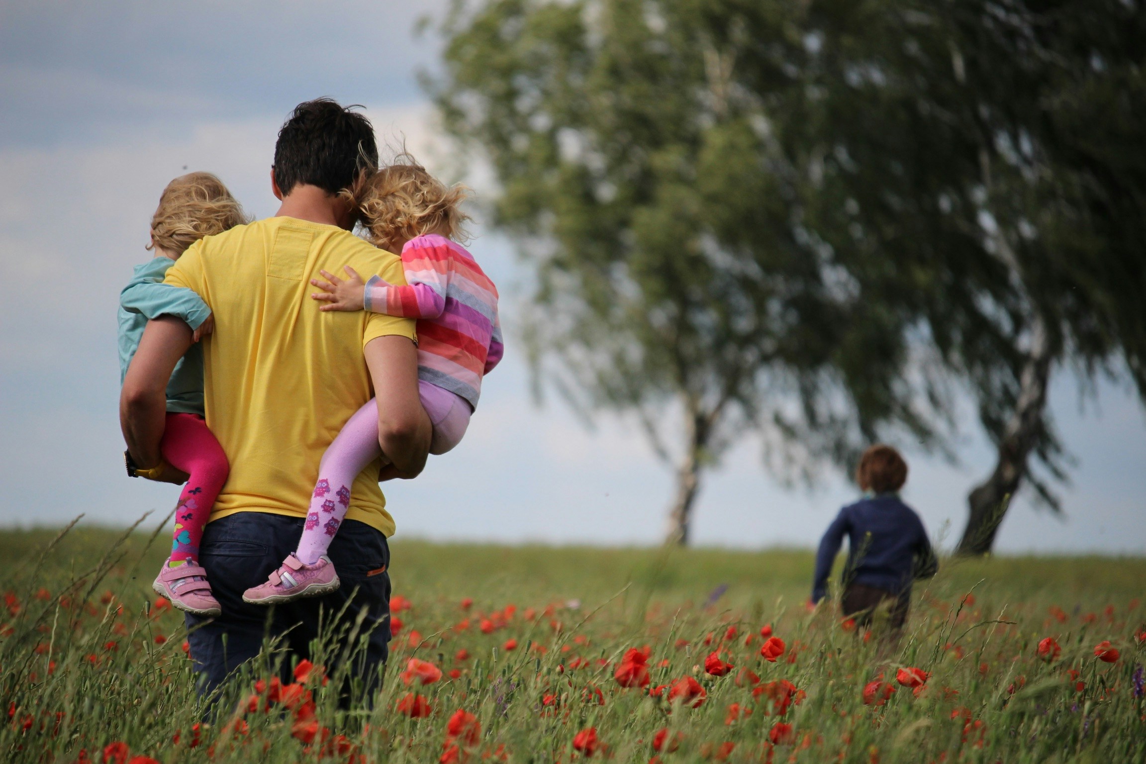 Dad out with his children in a field of poppies